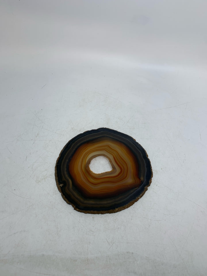 BROWN/ORANGE CRYSTAL SLICE W/ HOLE IN CENTER TRIVET.