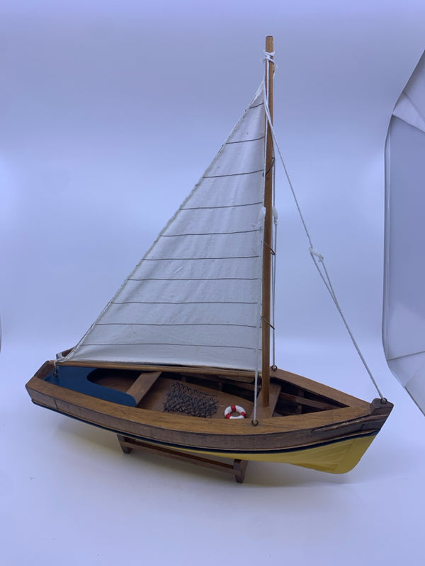 YELLOW AND WOOD SAILBOAT ON STAND.
