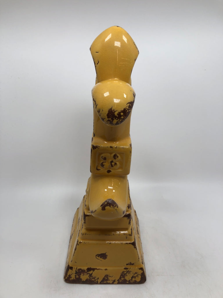 YELLOW FLEUR-DE-LIS FIGURINE.