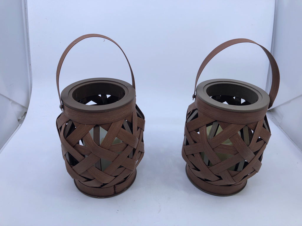 2 BROWN OPEN WEAVE LANTERNS WITH HANDLES AND BATTERY OPERATED CANDLES.