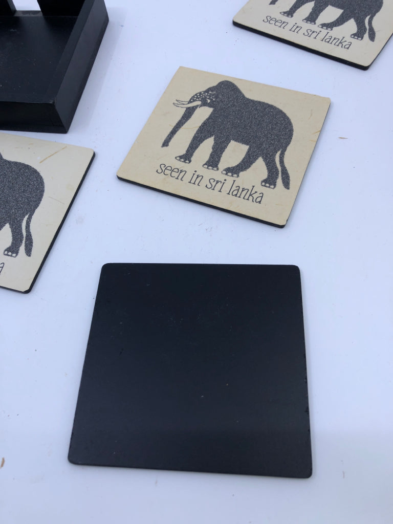4 ELEPHANT COASTERS IN BLACK HOLDER.