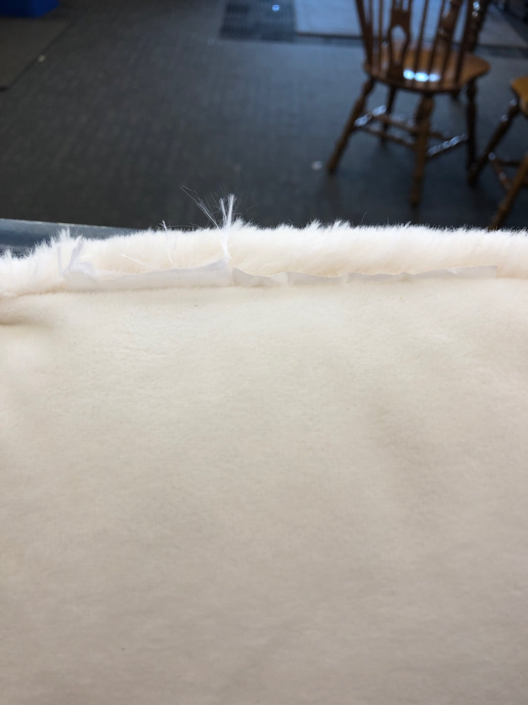 WHITE RIBBED FUZZY PILLOW.