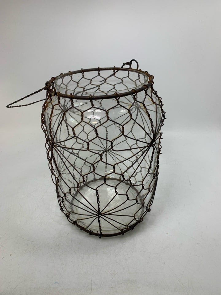 LARGE GLASS JUG W/ RUSTED METAL CAGE HANGING LANTERN.
