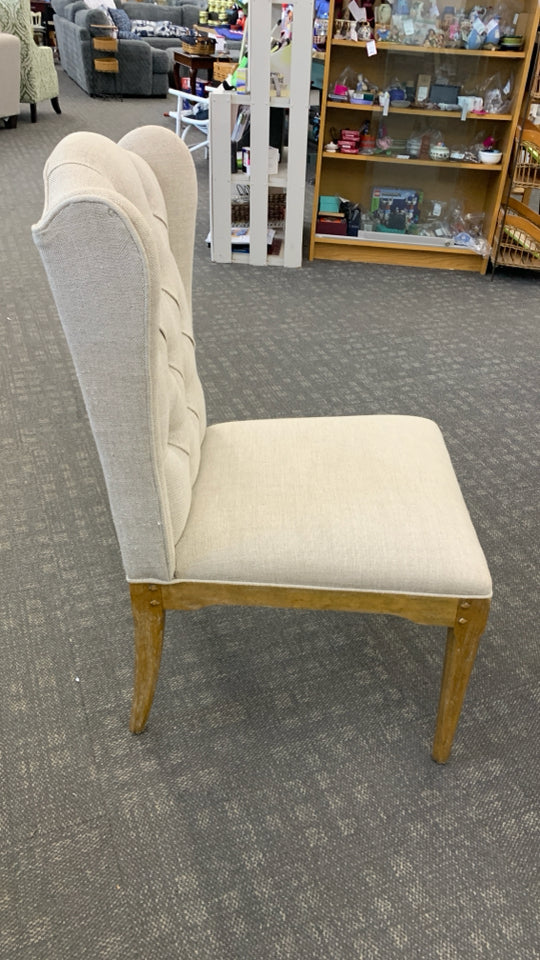 WHITE FABRIC CHAIR W/BROWN WOOD LEGS.