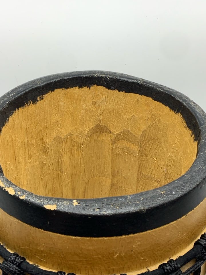 LIGHT COLORED DRUM W/BLACK ROPE.