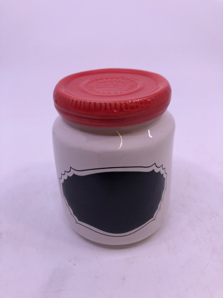 SMALL WHITE AND BLACK CANISTER W/ RED LID.