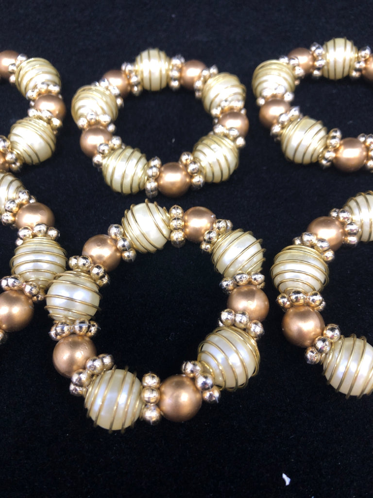 8 GOLD BEADED NAPKIN RINGS.