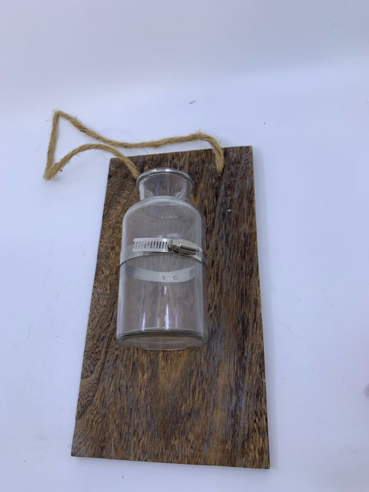 GLASS BOTTLE VASE ON PLANK.