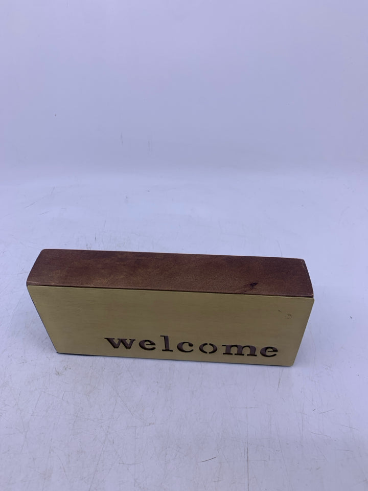 WOOD W/ BRASS COLORED METAL CUTOUT WELCOME.