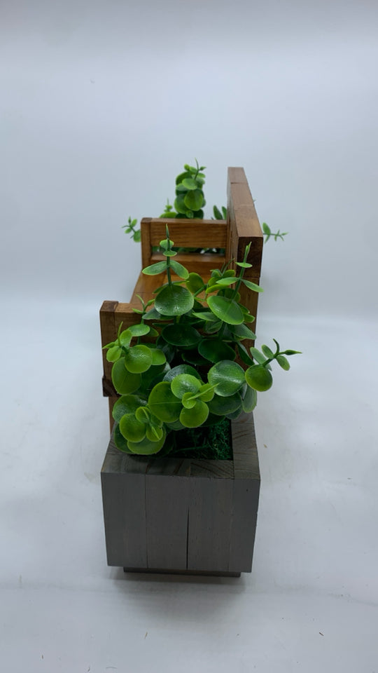 WOOD DOLL BENCH W/FAUX LEAVES IN GREY POTS.