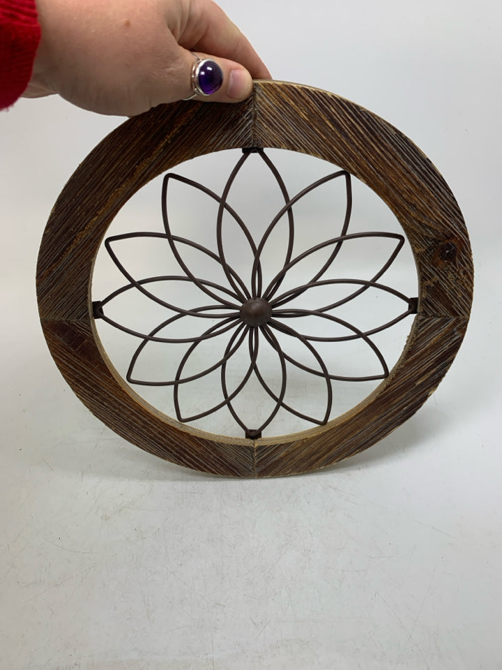 CIRCLE FRAME W/ METAL FLOWER IN CENTER.