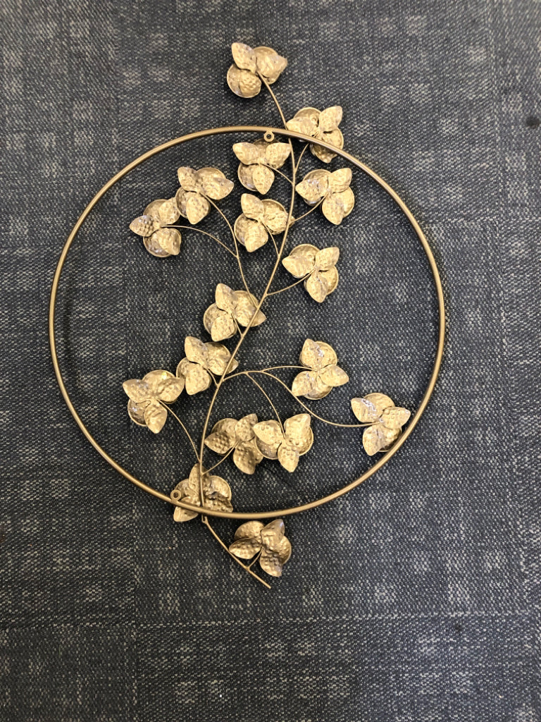 GOLD CIRCLE WITH FLORAL WALL HANGING.