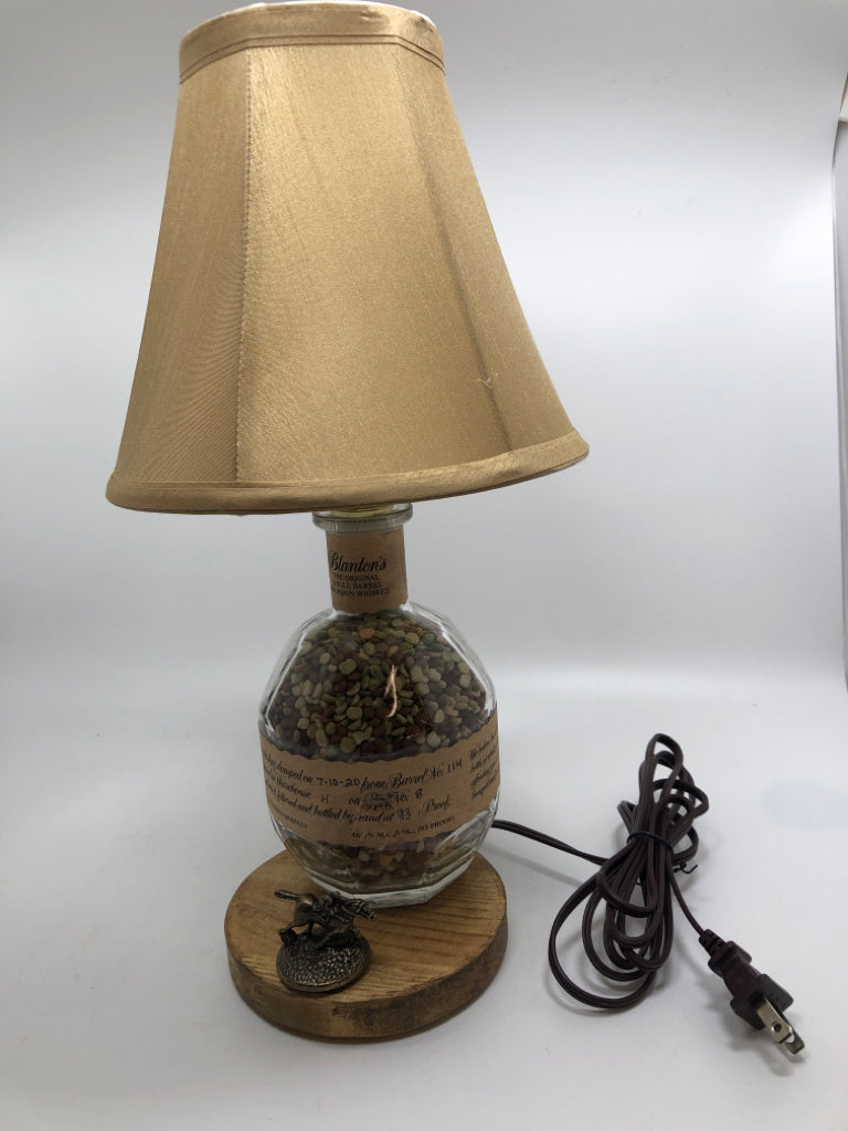 BOURBON BOTTLE LAMP W/TAN SHADE.