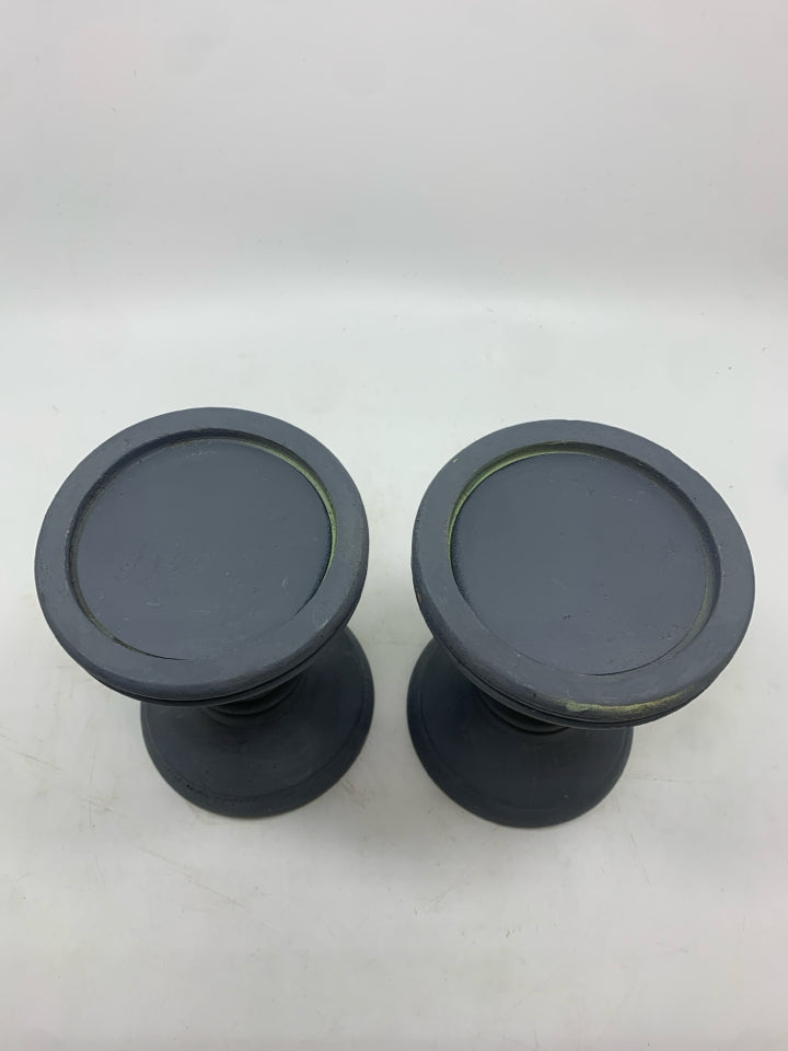 2 GREY RESIN PILLAR CANDLE HOLDERS.