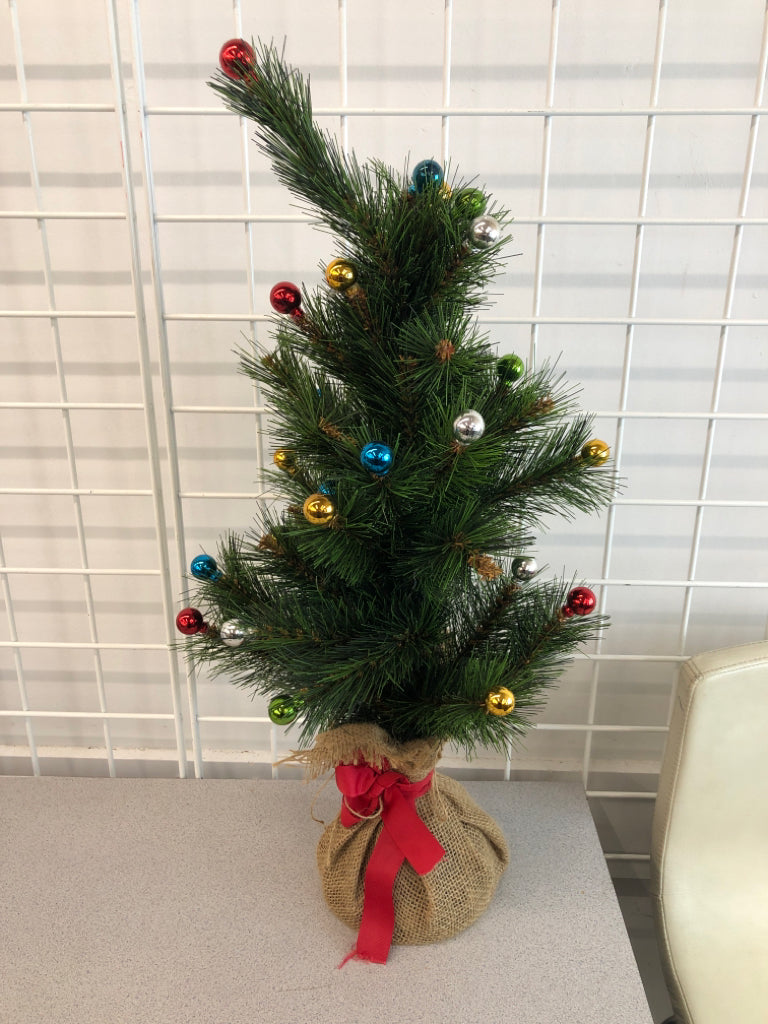 FAUX TREE W/COLORFUL ORNAMENTS IN BURLAP BASE.