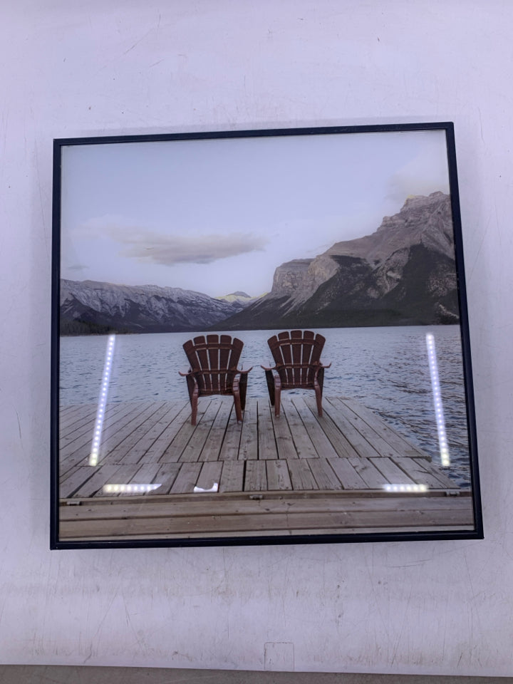 2 CHAIRS FACING WATER IN BLACK FRAME.