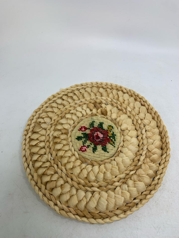 VTG BLONDE WOVEN CIRCLE TRIVET W/ NEEDLE POINT FLORAL CENTER.