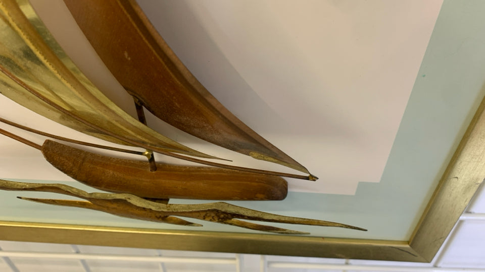 BRONZE METAL SHIPS MOUNTED ON GOLD FRAME.