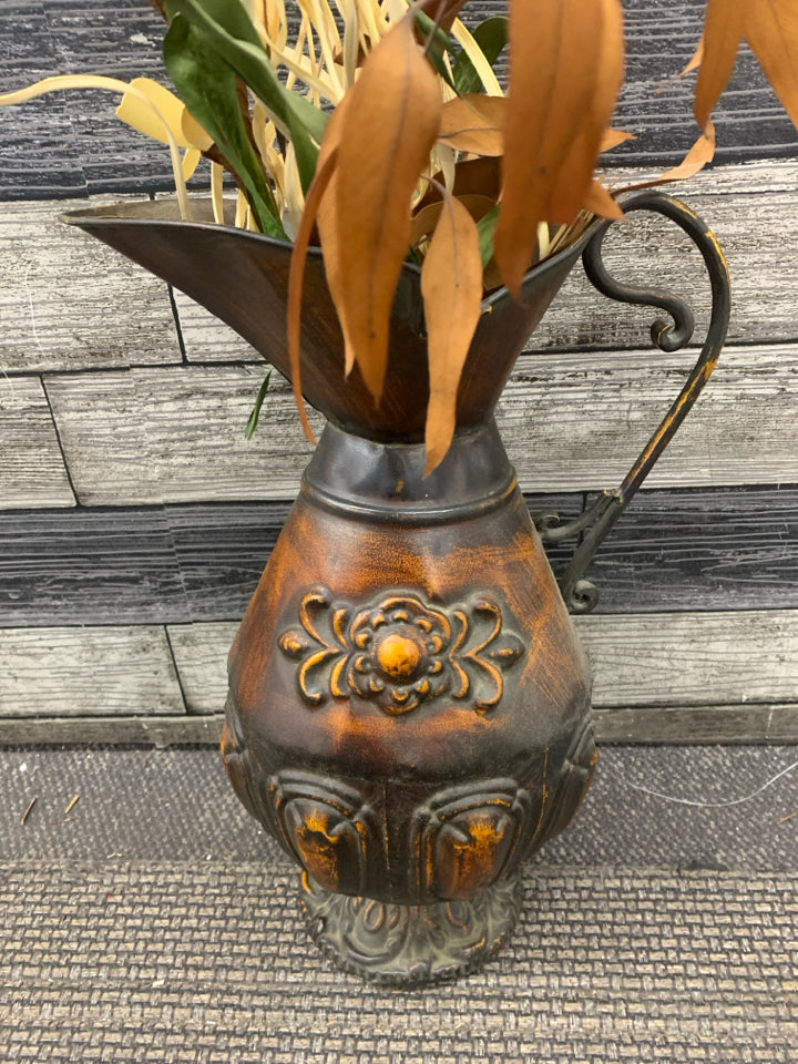 LARGE DISTRESSED METAL PITCHER W FAUX LEAVES.