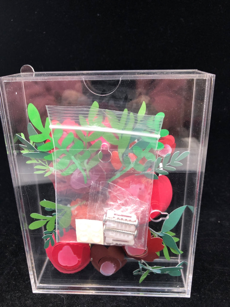 CLEAR PLASTIC SHADOW W/ ROLLING PAPER FLOWERS MERRY CHRISTMAS.