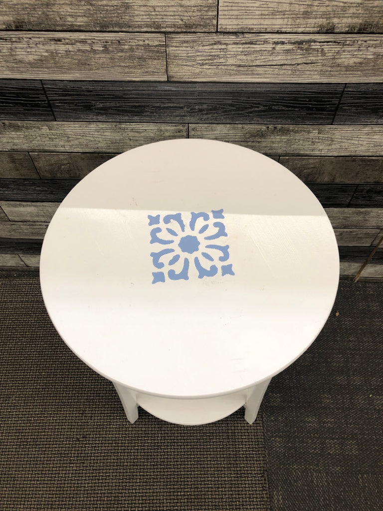 WHITE 3 SHELF ROUND SIDE TABLE W/PAINTED BLUE MEDALLION.