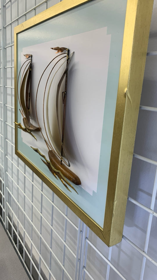 BRONZE METAL SHIPS MOUNTED ON GOLD FRAME.