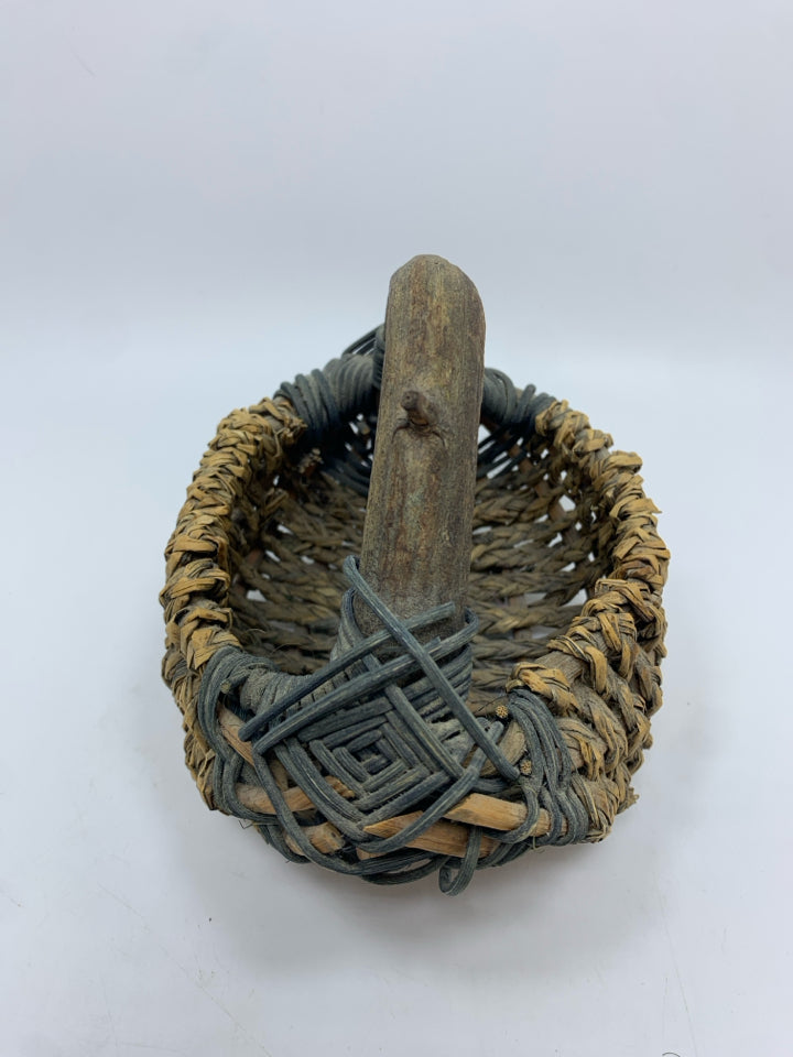 SM WOVEN BASKET W/BRANCH HANDLE.
