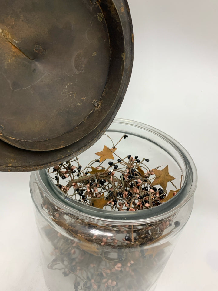 PRIMITIVE GARLAND IN METAL COVERED GLASS CANISTER.