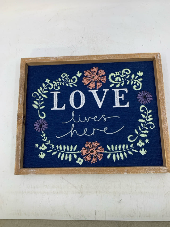 EMBROIDERED LOVE LIVES HERE NAVY BLUE BACKGROUND W/ FLOWERS.