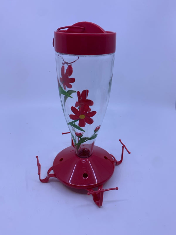 RED HUMMING BIRD FEEDER W/ RED FLOWERS.