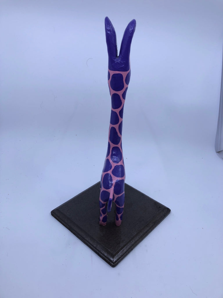 PINK AND PURPLE GIRAFFE ON WOOD STAND.