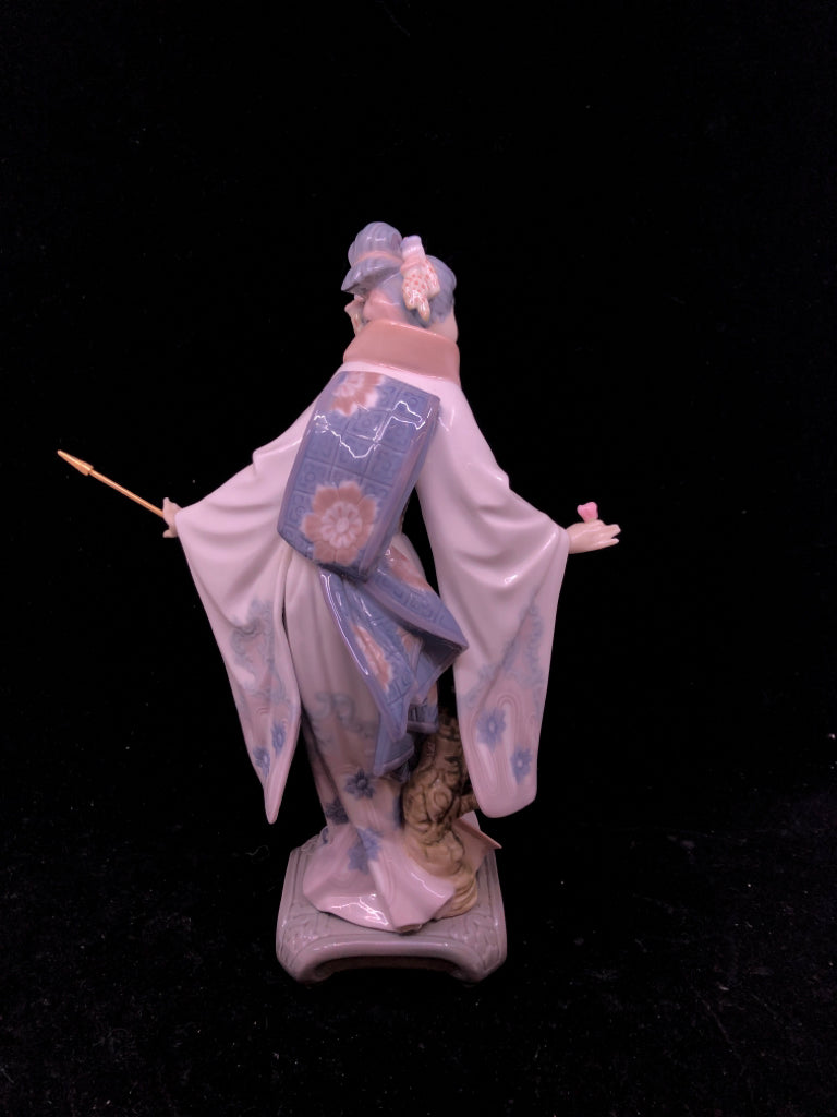 LLADRO WOMAN HOLDING UMBRELLA BENDING OVER.