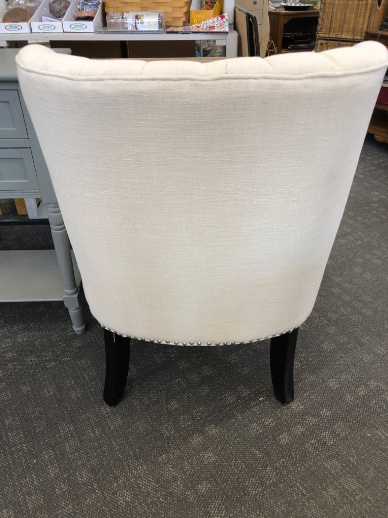 WHITE ACCENT CHAIR STUDDED BOTTOM W/ BLACK LEGS.