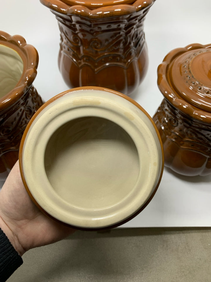 3 LIGHT BROWN SCROLL DETAILED CANISTERS.