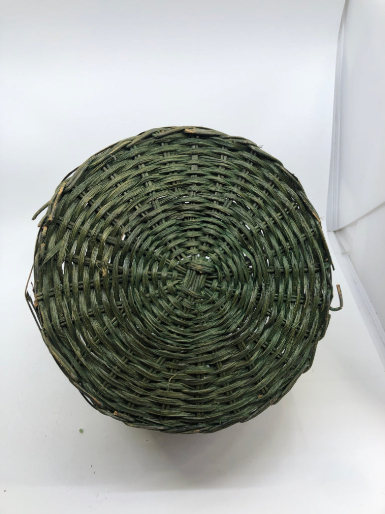 GREEN WOVEN BASKET W METAL HANDLE AND LEAVES.