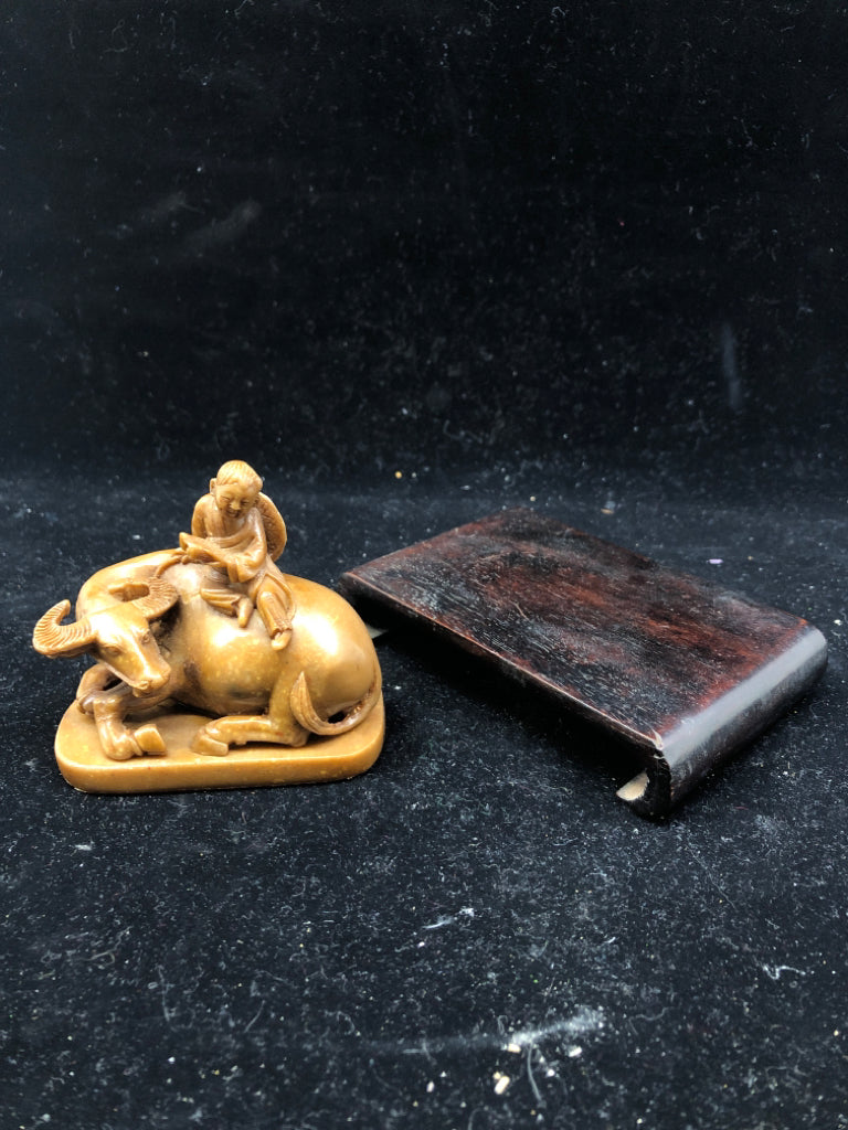 BROWN BULL & MAN FIGURINE ON WOOD SLAB.