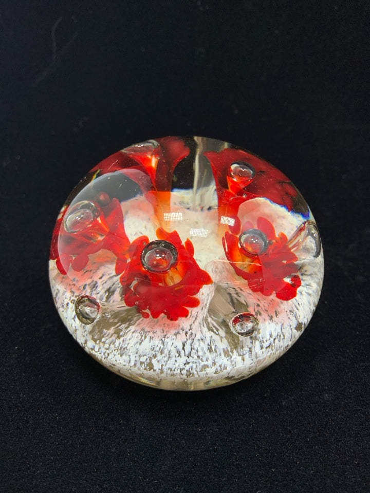 CLEAR GLASS PAPERWEIGHT W/WHITE/RED FLORAL DESIGN.