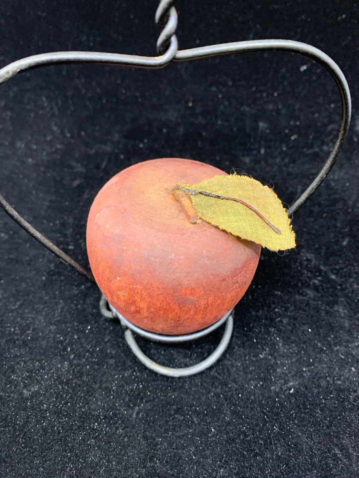 RED PRIMITIVE APPLE ON STAND.