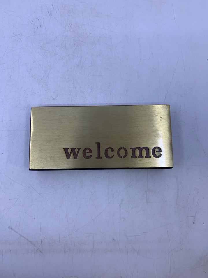 WOOD W/ BRASS COLORED METAL CUTOUT WELCOME.