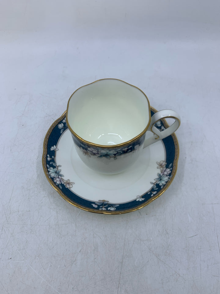 WHITE TEA CUP W/ BLUE/GOLD EDGE & FLOWERS.