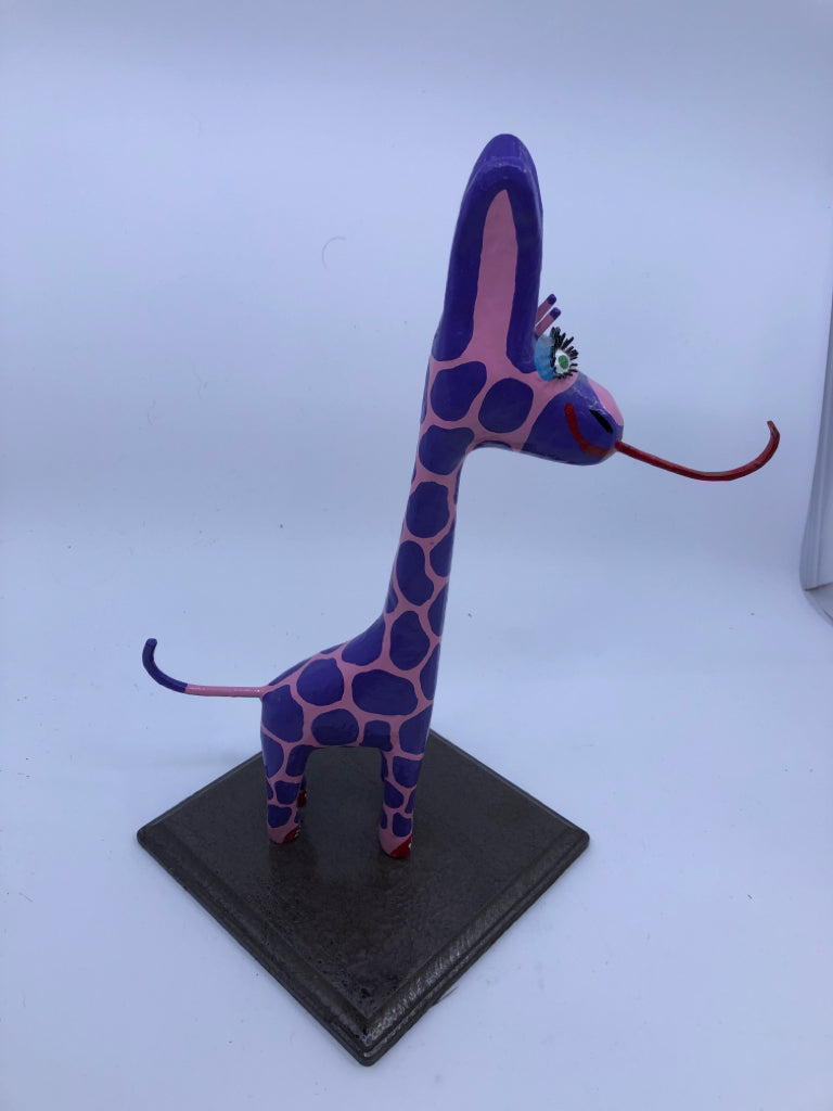 PINK AND PURPLE GIRAFFE ON WOOD STAND.
