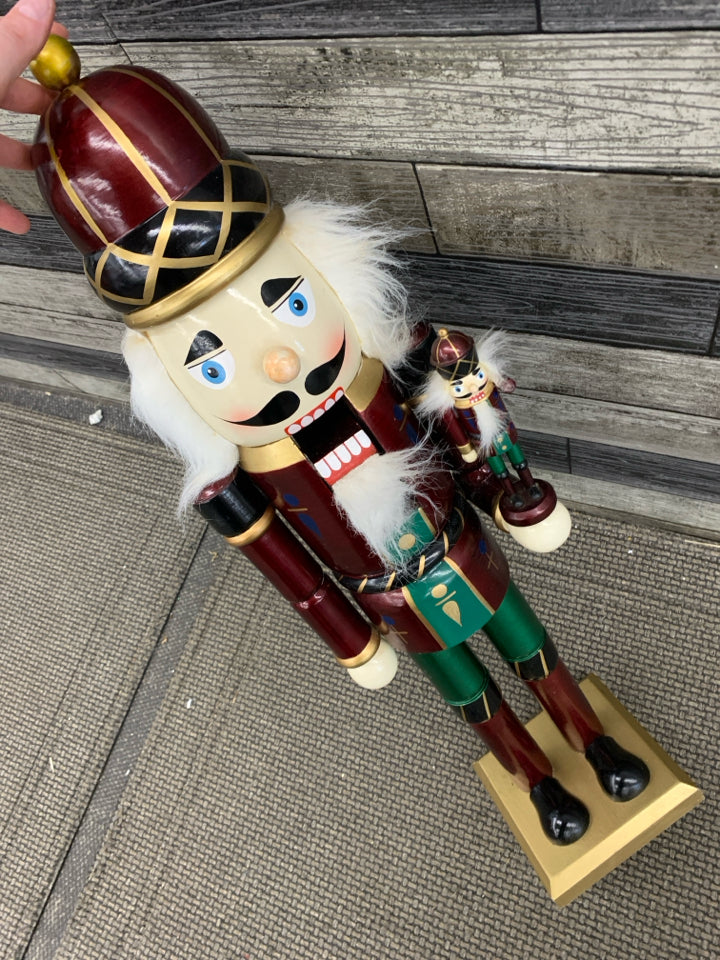 TALL NUTCRACKER HOLDING NUTCRACKER.
