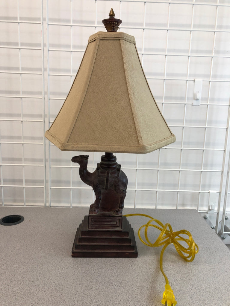 WOOD CAMEL BASE LAMP W/TAN SHADE.