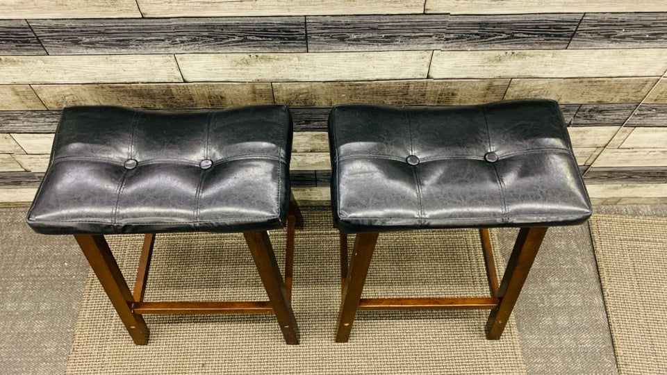 2 SADDLE SHAPED BAR STOOLS W FAUX LEATHER SEATS.