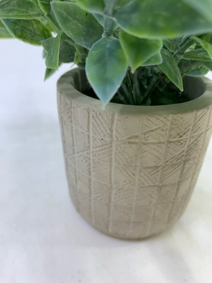 FAUX PLANT IN TEXTURED ROUND PLANTER.