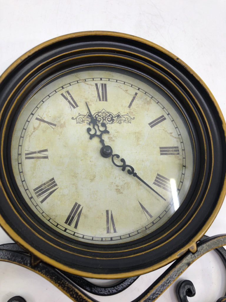 METAL BLACK SCROLL FOOTED CLOCK W/ GOLD DETAILS.
