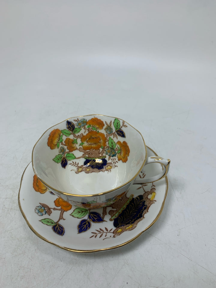ORANGE FLOWERS IN PLANTER W/ GOLD RIM.