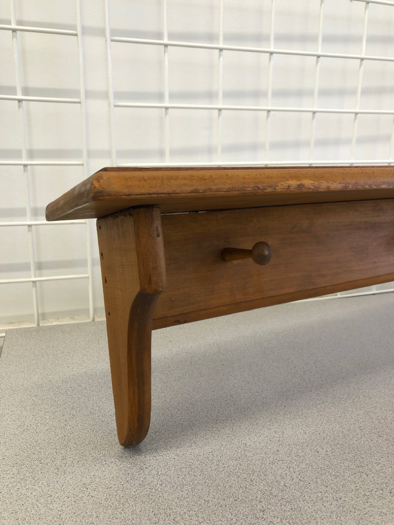 LIGHT BROWN WALL SHELF W/ COAT HOOKS.
