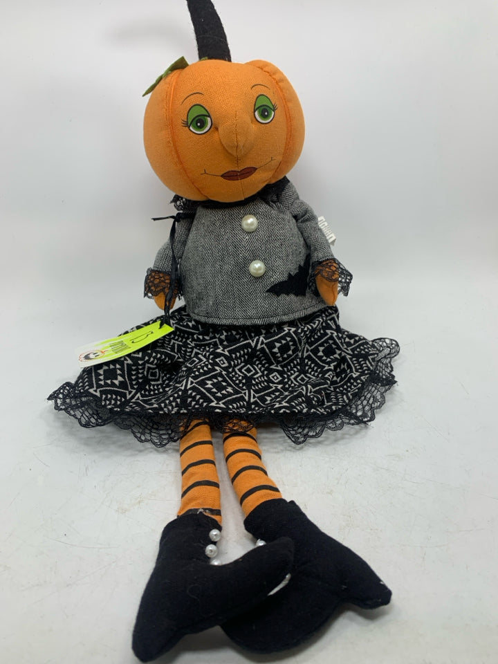 PLUSH PUMPKIN DOLL IN BLACK DRESS.