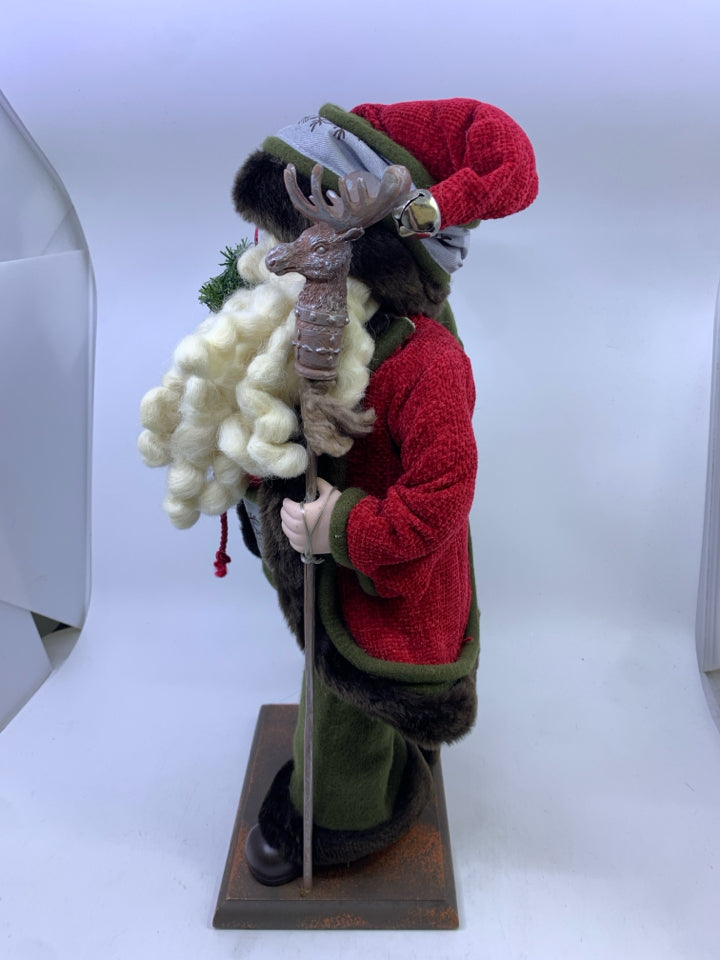 GREEN SANTA WITH DEER POLE HOLDING SACK.